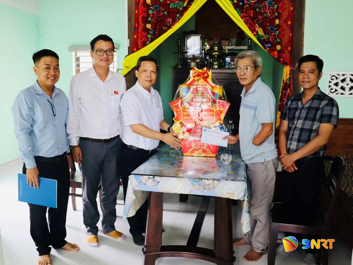 Trưởng ban Đô thị HĐND thành phố Lê Tùng Lâm (thứ ba từ trái sang) tặng quà cho ông Trương Xuân Yêm. Ảnh: QUỐC TUẤN