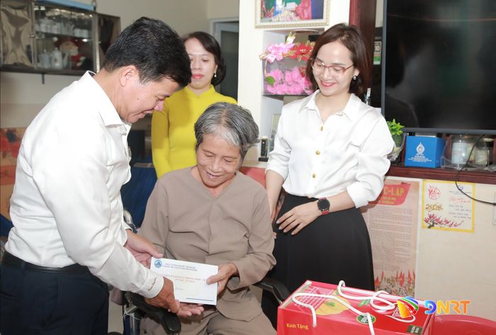 Trưởng ban Nội chính Thành ủy Võ Công Chánh (bên trái) thăm, tặng quà thương binh Đinh Thị Xứng. Ảnh: ĐẮC MẠNH