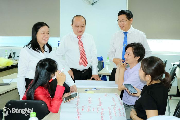 Phó Giám đốc Sở Khoa học và Công nghệ Võ Hoàng Khai (đứng giữa) trao đổi với các học viên trong lớp tập huấn cho giảng viên và cố vấn đào tạo khởi nghiệp tại Trường đại học Lạc Hồng. Ảnh: Vương Thế