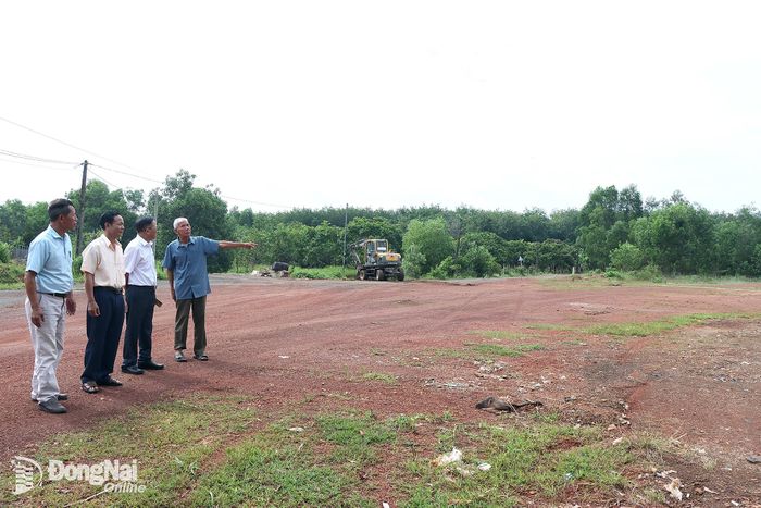 Ông Dương Đức Thùng (bìa phải) và cán bộ khu phố 1, phường Đồng Xoài thăm khu đất do gia đình ông hiến làm đường Hải Thượng Lãn Ông.