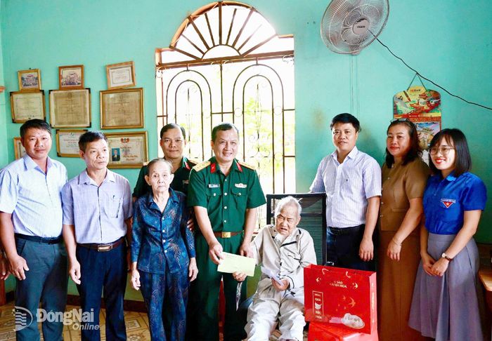 Đại tá Vũ Văn Định, Phó chủ nhiệm Chính trị Binh đoàn 16, trao quà tri ân ông Võ Vân, ấp Tân Phước, xã Đồng Tâm thương binh hạng 4/4.