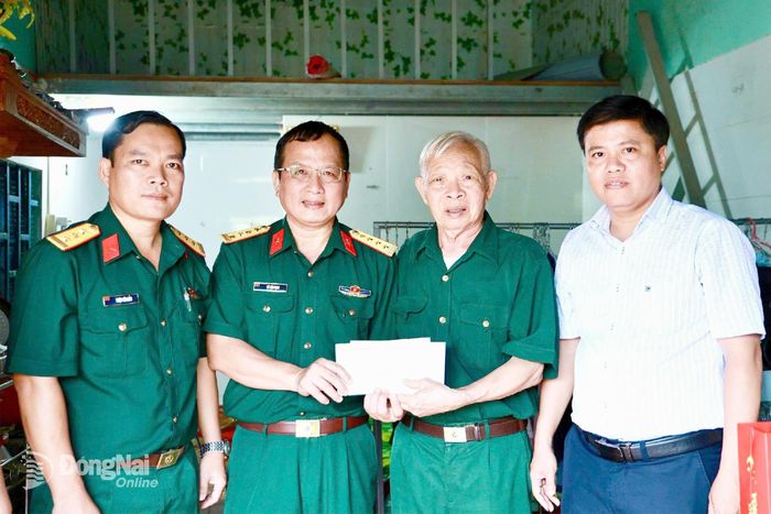 Đại tá Vũ Văn Định, Phó chủ nhiệm Chính trị Binh đoàn 16, trao quà tri ân ông Phạm Thanh Tường, người hoạt động kháng chiến bị nhiễm chất độc hóa học tại ấp Cầu 2, xã Đồng Tâm.