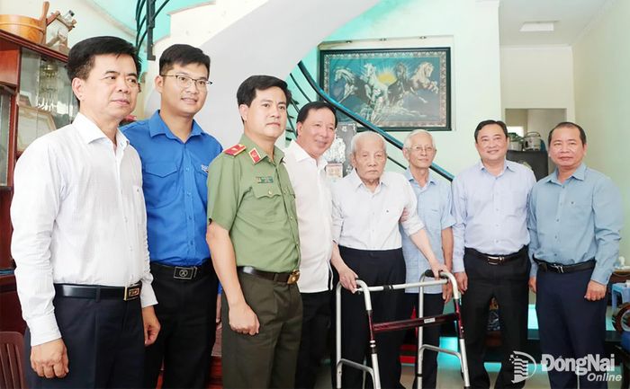 Đồng chí Nguyễn Văn Út, Phó Bí thư Thành ủy, Chủ tịch UBND thành phố và thành viên đoàn công tác chụp ảnh lưu niệm với đồng chí Nguyễn Văn An, cán bộ tiền khởi nghĩa và gia đình. Ảnh: Phạm Tùng