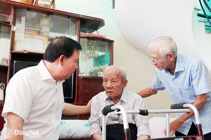 Đồng chí Nguyễn Văn Út, Phó Bí thư Thành ủy, Chủ tịch UBND thành phố thăm hỏi, động viên đồng chí Nguyễn Văn An, cán bộ tiền khởi nghĩa. Ảnh: Phạm Tùng