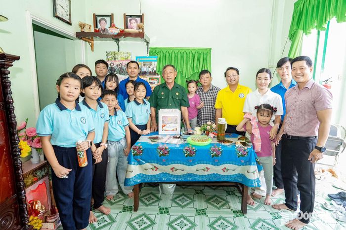 Đại diện các đơn vị và các em thiếu nhi chụp ảnh lưu niệm với một thương binh trên địa bàn phường Trấn Biên. Ảnh: ĐVCC
