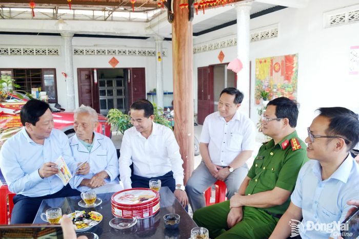 Cụ Đỗ Hồng Giang (98 tuổi), cán bộ tiền khởi nghĩa, giới thiệu với đồng chí Thái Bảo, Phó Bí thư Thành ủy, Trưởng ban Tổ chức Thành ủy và thành viên đoàn công tác về những bài thơ cụ vừa sáng tác. Ảnh: Phương Hằng