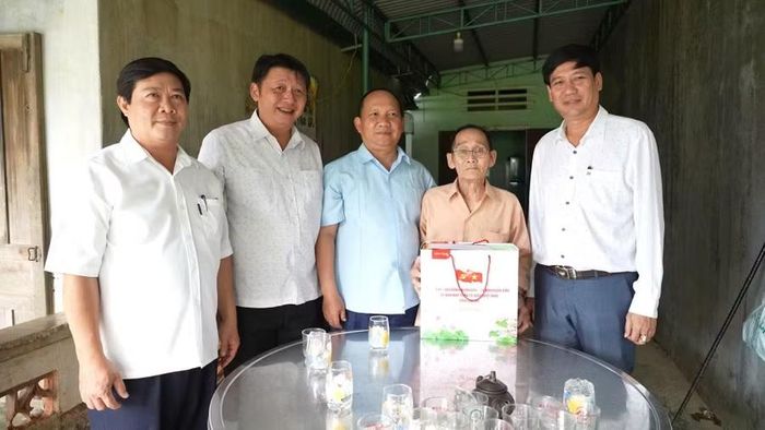 Phó Bí thư Thường trực Tỉnh ủy Rah Lan Chung (thứ 3 từ trái sang) thăm, tặng quà cho thương binh Huỳnh Kim Chi (thôn Vạn Trung, xã Ân Hảo). Ảnh: Dũng Nhân