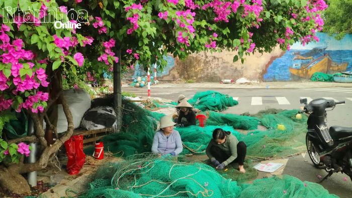 Người dân vá lại lưới giã sau chuyến đi biển.