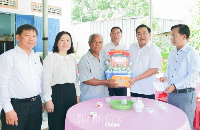 Phó Chủ tịch UBND tỉnh Trịnh Minh Hoàng trao quà của tỉnh và quà cá nhân cho ông Mai Liên.