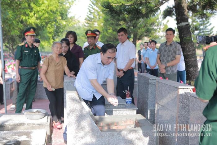 Các đại biểu và thân nhân thực hiện nghi lễ an táng hài cốt liệt sĩ Thi Xuân Lan tại phần mộ