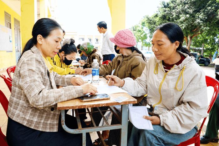 Chị Thị Ngôn (bên phải) làm thủ tục xét tuyển cho con trai vào học tại Trường Phổ thông nội trú liên cấp Tiểu học và THCS Quảng Trực