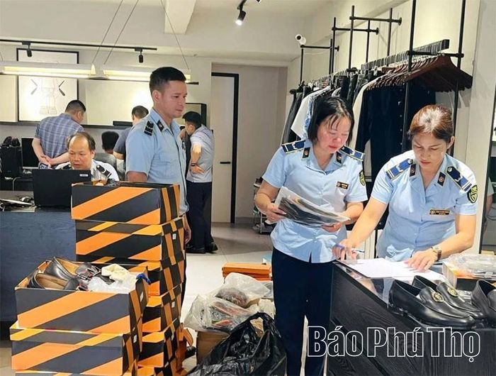 Lực lượng chức năng kiểm tra, phát hiện hàng hóa giả mạo các thương hiệu thời trang cao cấp tại một cơ sở kinh doanh trên địa bàn phường Việt Trì.
