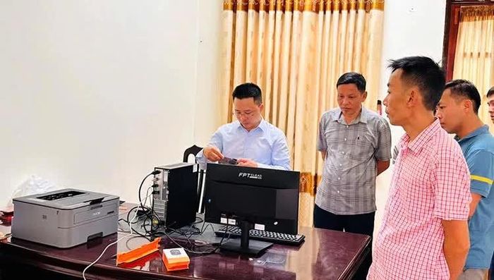 Cán bộ xã Minh Hóa lắp đặt, hướng dẫn cán bộ thôn sử dụng các thiết bị công nghệ thông tin - Ảnh: C.T