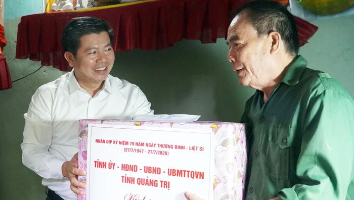 Đồng chí Trần Vũ Khiêm, Phó Bí thư Thường trực Tỉnh ủy, Trưởng đoàn đại biểu Quốc hội tỉnh tặng quà thương binh Trần Xuân Thời, phường Ba Đồn - Ảnh: N.M