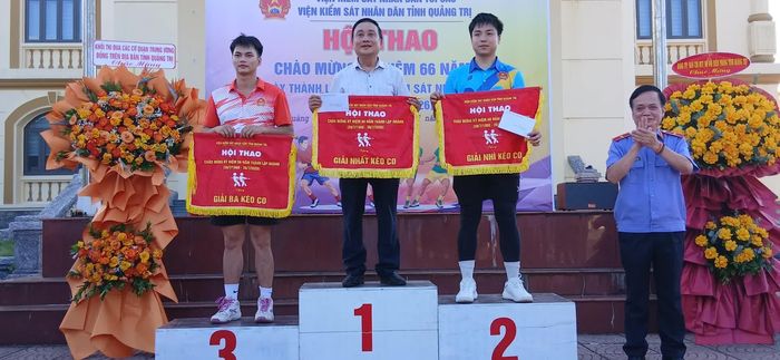 Ban Tổ chức trao cờ và phần thưởng cho các đội đạt thành tích cao ở môn thi đấu kéo co tập thể - Ảnh: H.Đ