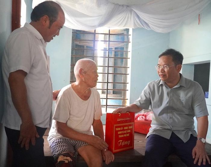Phó Bí thư Thường trực Thành ủy, Chủ tịch HĐND thành phố Phạm Đức Tiến trò chuyện, động viên thương binh Mai Xuân Tiệp, suy giảm khả năng lao động 41%. Ảnh Lê Thọ