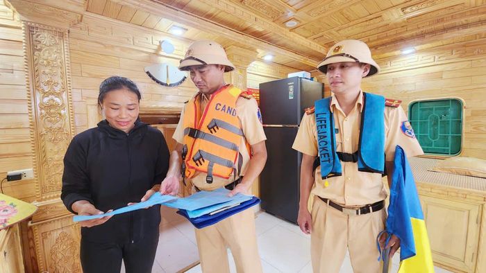 Cán bộ đội Cảnh sát đường thủy số 2 phát tờ rơi về công tác đảm bảo an toàn trước mùa mưa bão.