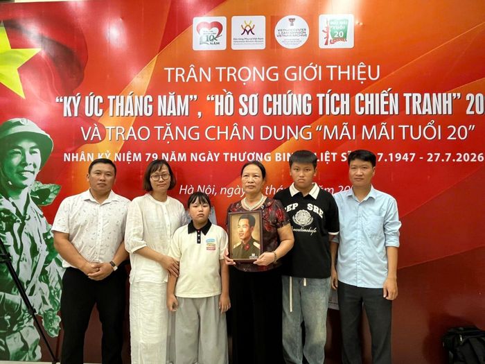 Bà Đặng Thị Chí cùng các con, cháu bên chân dung phục dựng của liệt sĩ Đặng Quang Trung.