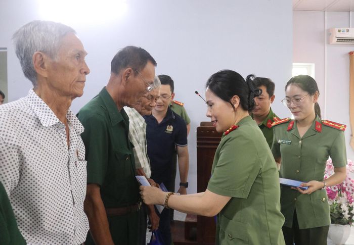 Phó Cục trưởng Cục công tác Chính trị Đại tá Từ Thị Thu Hòa tặng quà đến các thương binh, bệnh binh, cựu chiến binh có hoàn cảnh khó khăn trên địa bàn phường Thới Sơn. Ảnh: Nghiêm Túc