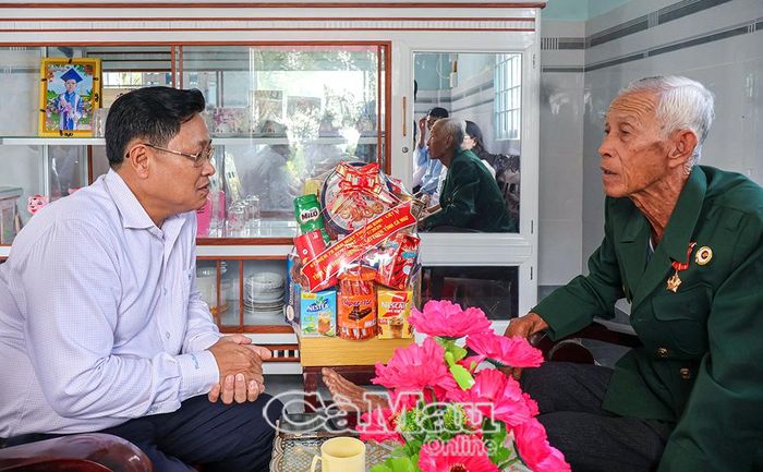 Đồng chí Bùi Tấn Bảy trò chuyện cùng ông Trần Văn Thiên, thương binh 4/4, tại ấp Cây Sộp.