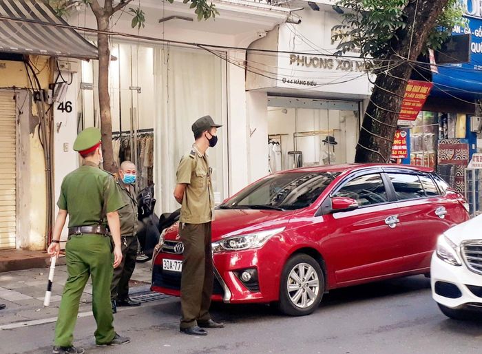 Lực lượng chức năng xử lý phương tiện vi phạm dừng đỗ trái quy định. Ảnh: N.Lộc