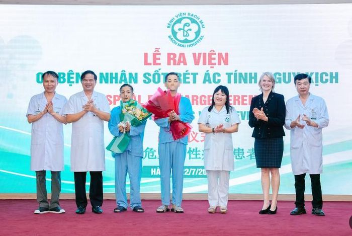 Lãnh đạo Bệnh viện Bạch Mai, Viện Y học Nhiệt đới và đại diện WHO chúc mừng 2 bệnh nhân ra viện. Ảnh: Thế Anh