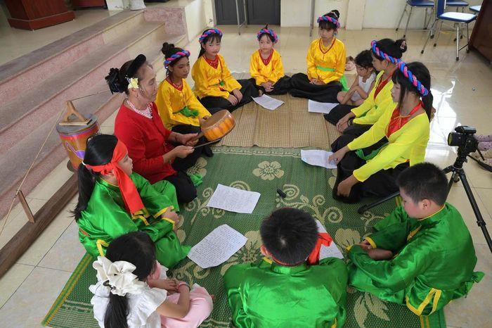 NNƯT Kiều Thị Mách truyền dạy những làn điệu hát trống quân cho các em nhỏ trong làng. Ảnh: P. Sỹ