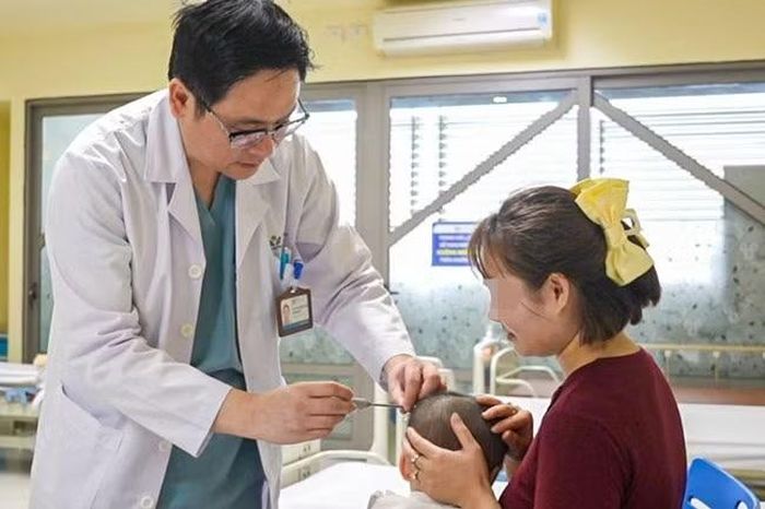 Tiến sĩ, bác sĩ Đặng Hoàng Thơm, Trưởng khoa Sọ mặt và Tạo hình khám cho bệnh nhi.