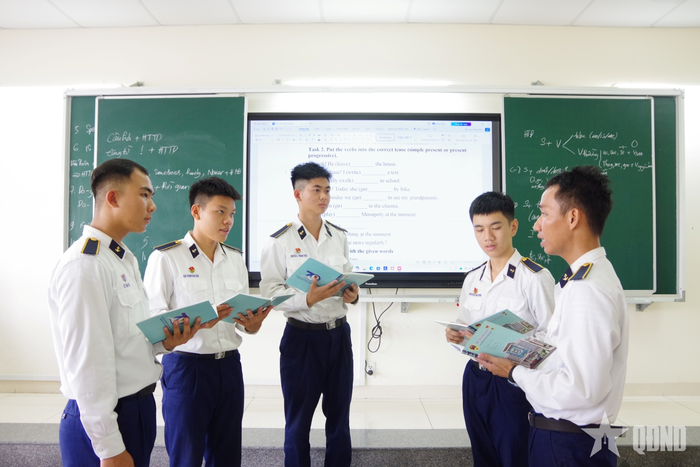 Binh nhất Nguyễn Lê Thành Triết trao đổi học tập tiếng Anh trong giờ tự học tại giảng đường.