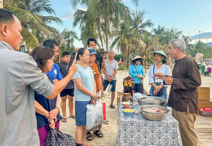  Du khách tìm hiểu quy trình làm mắm truyền thống qua những chia sẻ của ngư dân địa phương. Ảnh: XUÂN QUỲNH 