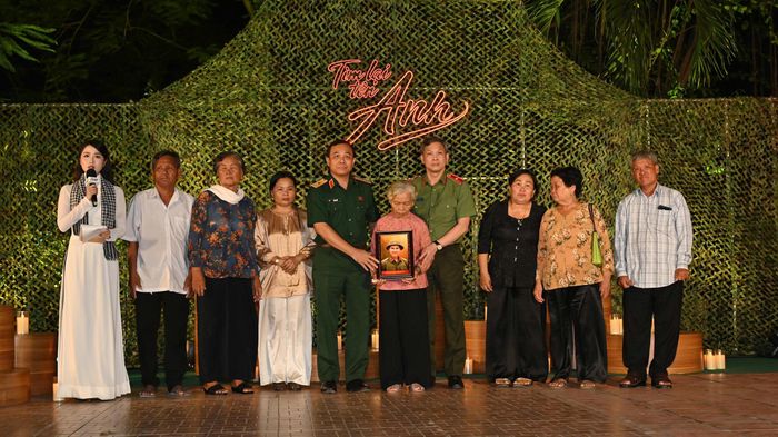  Thiếu tướng Vũ Văn Điền, Tư lệnh Bộ Tư lệnh TPHCM và Thiếu tướng Tạ Văn Đẹp, Phó Giám đốc Công an TPHCM trao tặng bà Nguyễn Thị Lệ cùng gia đình bức chân dung liệt sĩ Huỳnh Văn Quên 