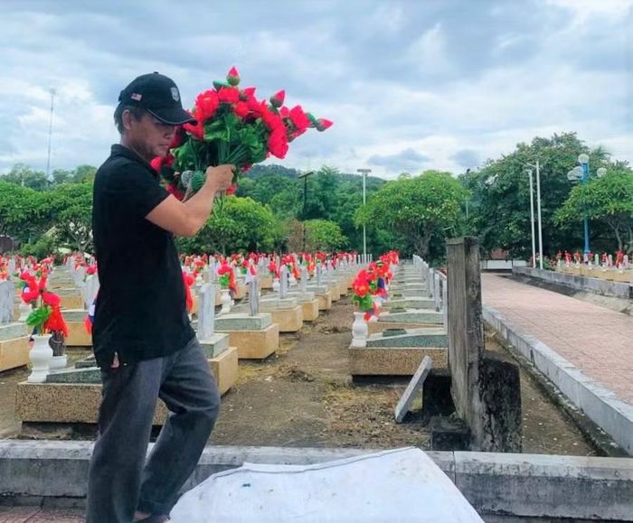 Giáo viên Trường THCS Anh Sơn (Anh Sơn, Nghệ An) chăm sóc các phần mộ tại Nghĩa trang liệt sỹ quốc tế Việt - Lào. Ảnh: NTCC