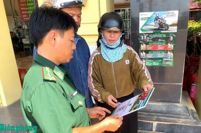 Cán bộ Đồn Biên phòng cửa khẩu Lộc Thịnh tuyên truyền, hướng dẫn từng người dân về cách nhắn tin tố giác tội phạm. Ảnh: Đơn vị cung cấp