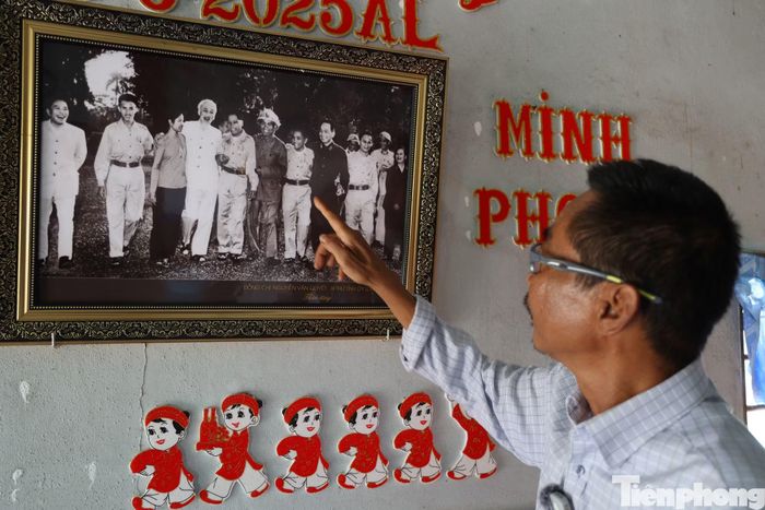 Ông Nhờ khoe tấm hình cha mình được diện kiến Chủ tịch Hồ Chí Minh và Đại tướng Võ Nguyên Giáp trong lần ra Bắc. Ảnh: Nguyễn Tiến