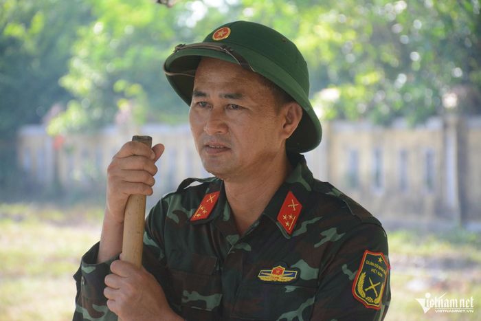 Thượng úy Trần Dẫn nhễ nhại mồ hôi khi lấy mẫu dưới cái nắng như đổ lửa, giữa gió Lào bỏng rát. Ảnh: Lê Bằng