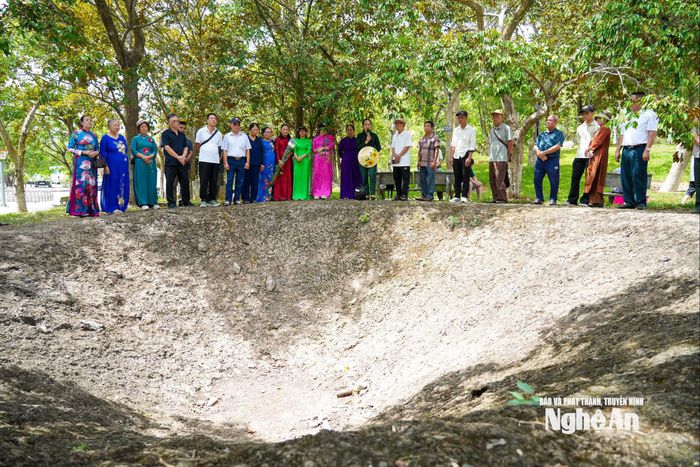 Du khách nghe thuyết minh bên hố bom lịch sử tại Khu Di tích quốc gia đặc biệt Truông Bồn.