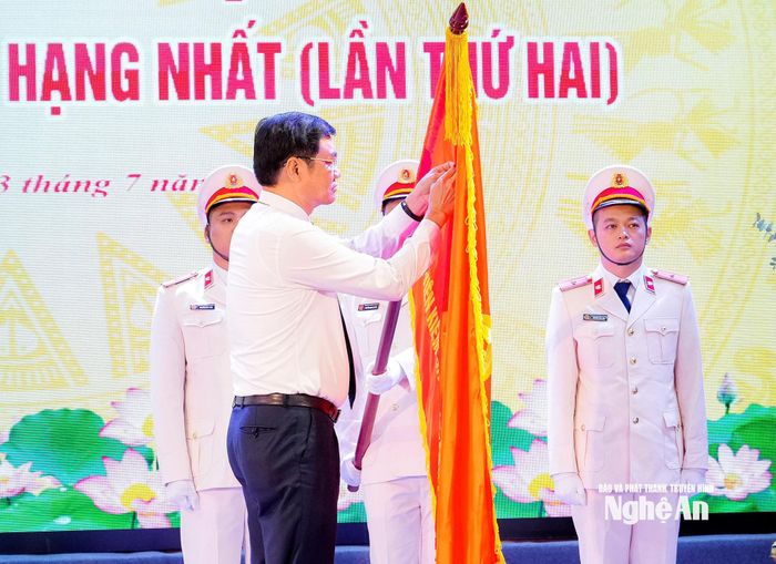 Phó Bí thư Thường trực Tỉnh ủy, Chủ tịch HĐND tỉnh Hoàng Nghĩa Hiếu gắn Huân chương lên Lá cờ truyền thống của Viện Kiểm sát nhân dân tỉnh. Ảnh: Phạm Bằng