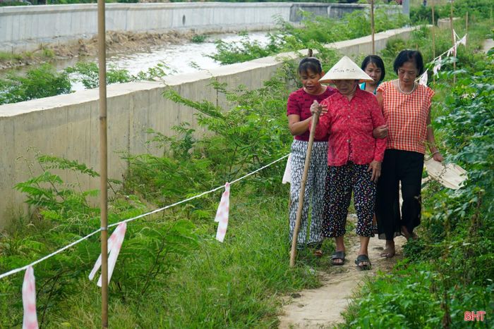 Người dân đi lại trên lối đi tạm nhỏ hẹp ven kênh 19/5.