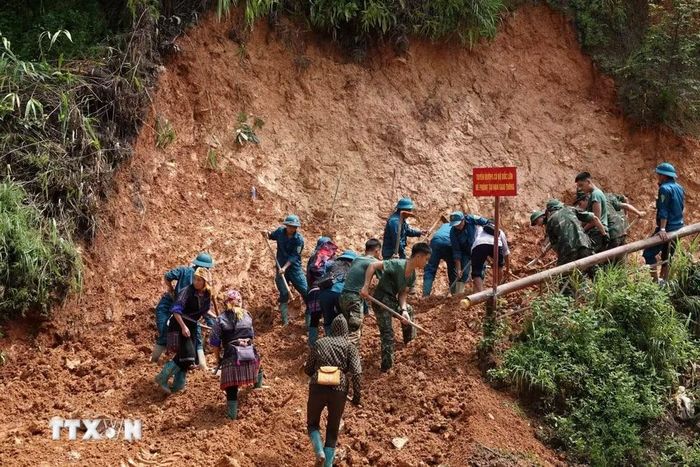 Các lực lượng gồm bộ đội, dân quân tự vệ giúp xã Mù Cang Chải khắc phục các tuyến đường sạt lở. (Ảnh: Tuấn Anh/TTXVN)