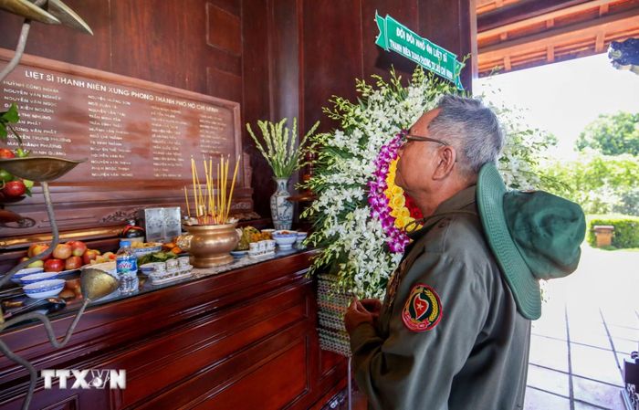 Ông Trần Toàn Thư, cựu Thanh niên xung phong Thành phố Hồ Chí Minh, lặng người trước những dòng tên của các đồng đội đã mãi mãi nằm lại trên chiến trường biên giới Tây Nam. (Ảnh: Giang Phương/TTXVN)