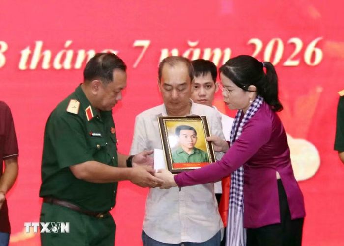 Phút nghẹn ngào của thân nhân liệt sỹ đón nhận di ảnh liệt sỹ đã được phục dựng. (Ảnh: Xuân Khu/TTXVN)