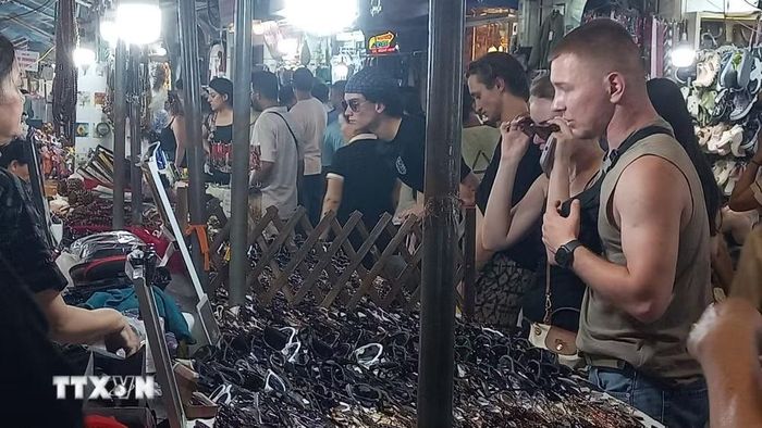 Khách quốc tế yêu thích việc mua sắm quà lưu niệm tại chợ đêm phố cổ Hà Nội. (Ảnh: Tuyết Mai/TTXVN)