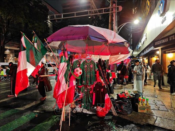 Cờ, mũ, kèn và áo đấu mang màu cờ Mexico được bày bán nhộn nhịp trong trận đấu Mexico- Ecuador.