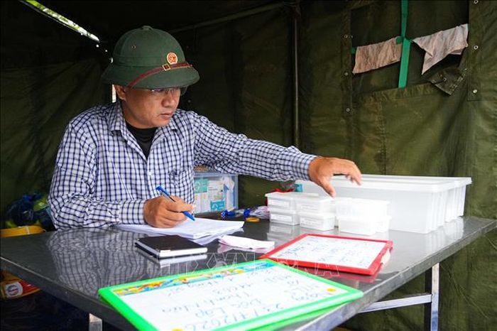 Lực lượng chuyên môn ghi thông tin để giám định ADN tại Nghĩa trang Liệt sĩ Độc Lập, xã Thanh Nưa, tỉnh Điện Biên. Ảnh: Phan Quân/TTXVN