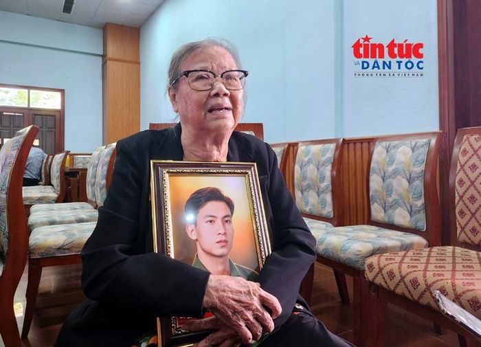 Bà Đỗ Thị Ân xúc động khi ôm di ảnh chồng là liệt sĩ Lương Đình Canh sau khi được phục dựng.