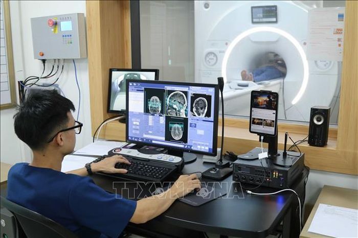 Kỹ thuật viên Bệnh viện vận hành hệ thống máy chụp Cắt lớp vi tính tích hợp trí tuệ nhân tạo. Ảnh: Quang Duy/TTXVN