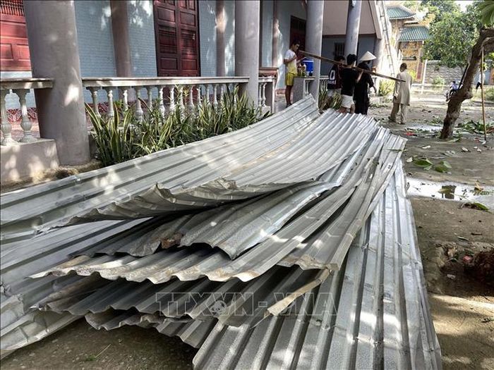 Những tấm tôn bị lốc xoáy cuốn phăng xuống đất tại chùa Sùng Ân.