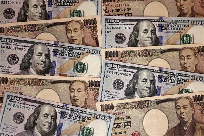 Đồng 10.000 yen và đồng 100 USD. Ảnh: AFP/TTXVN
