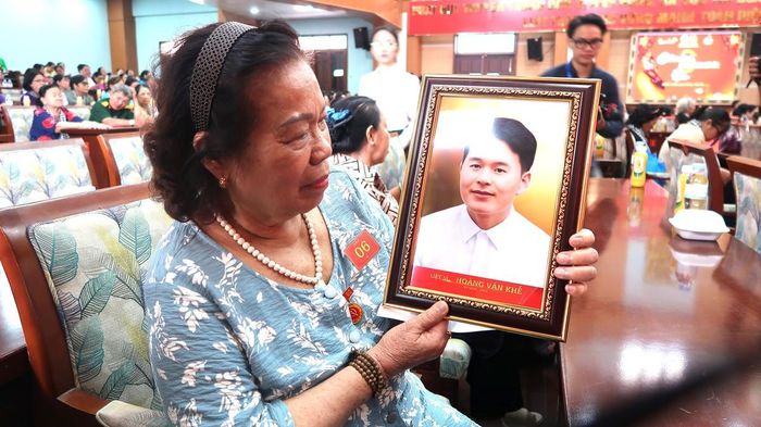 Cô Nguyễn Thị Thuận (Phú Thạnh, TPHCM), vợ liệt sĩ Hoàng Văn Khế, xúc động khi nhìn ảnh phục dựng của chồng. 