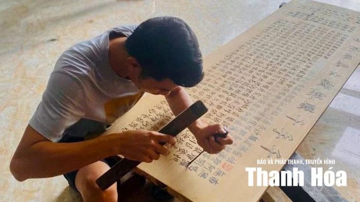 Nghệ nhân tỉ mỉ đục tay từng nét chữ trên gỗ.